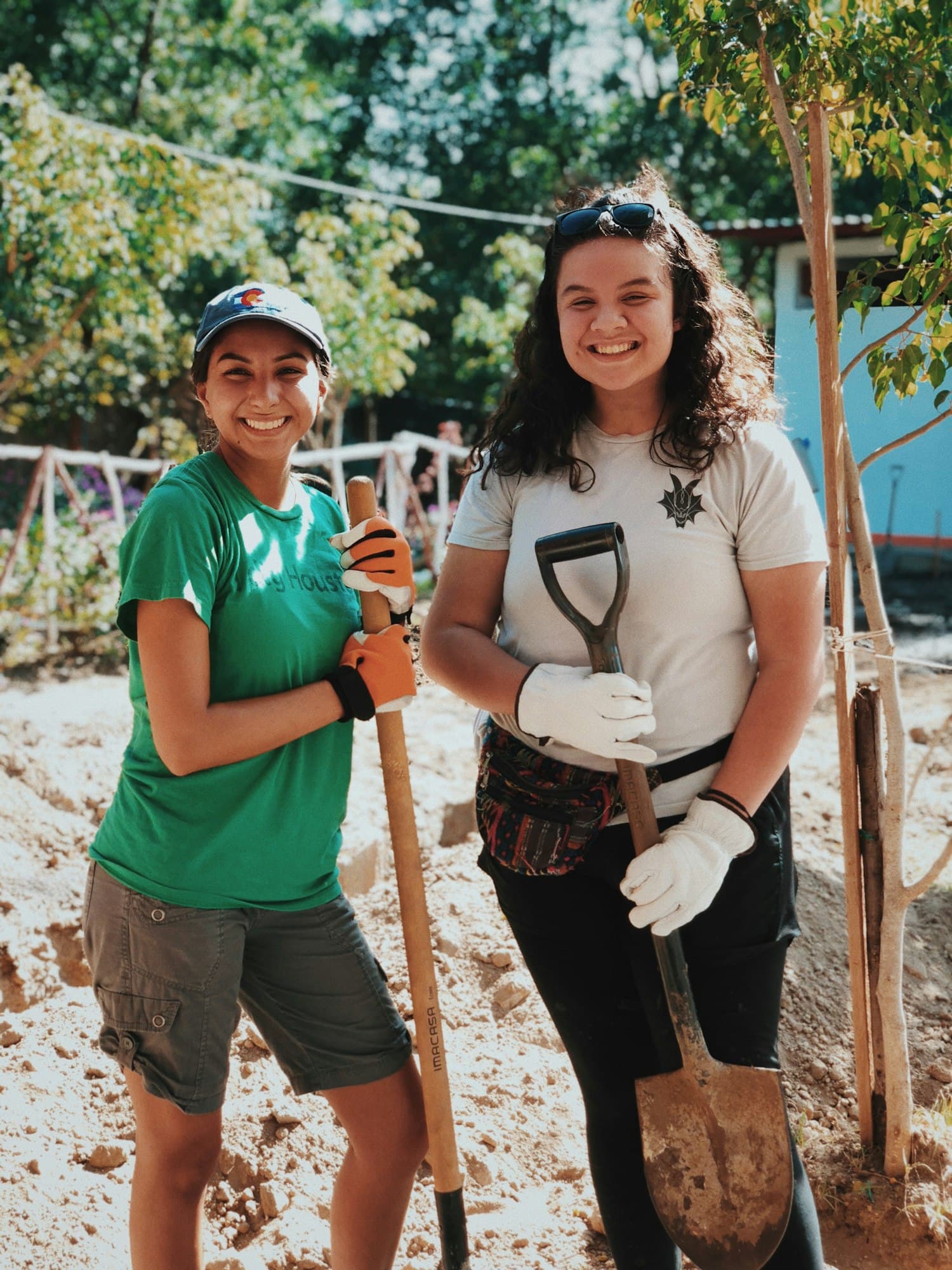 Community volunteers smiling together during an outdoor service project.