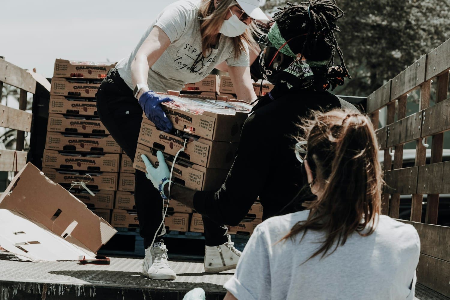 Volunteers unloading boxes of supplies at a neighborhood food and goods distribution.