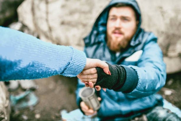 An outreach worker reaches out to offer help to a person living on the street.